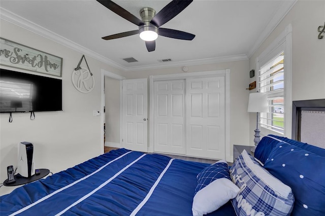 bedroom with ceiling fan, a closet, and ornamental molding