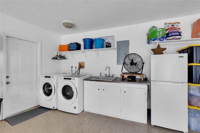 clothes washing area featuring sink, electric panel, cabinets, and separate washer and dryer