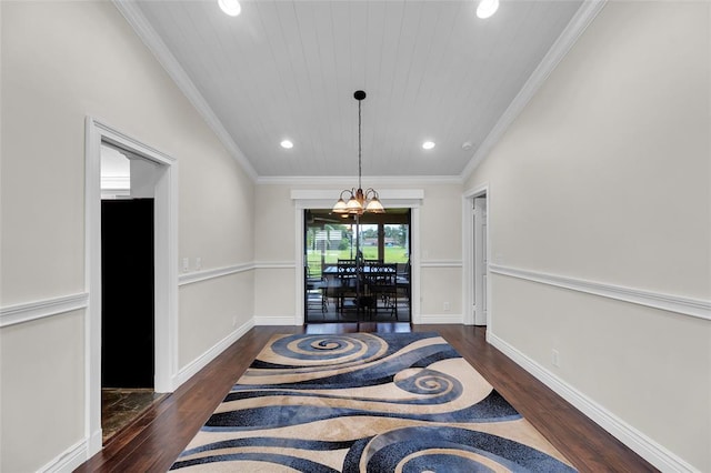 interior space featuring an inviting chandelier, dark hardwood / wood-style flooring, ornamental molding, and vaulted ceiling