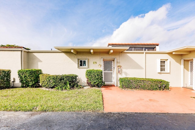 view of front of property with a patio and a front yard