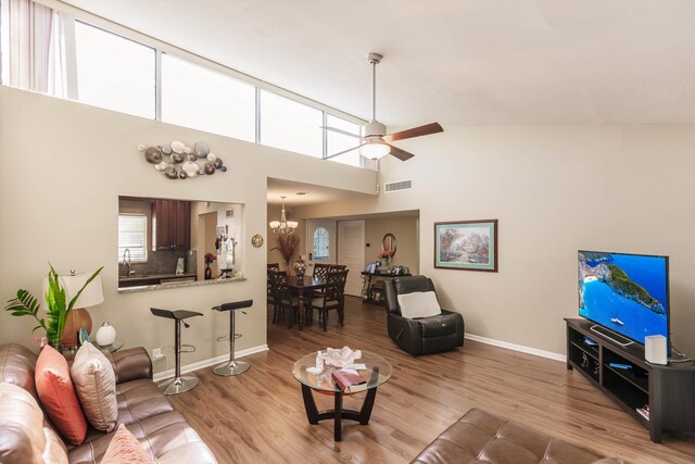 living room featuring vaulted ceiling, ceiling fan, and wood-type flooring