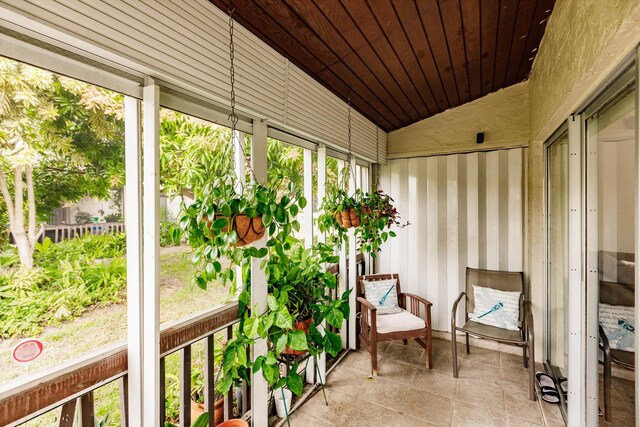 sunroom / solarium with wooden ceiling, vaulted ceiling, and a wealth of natural light