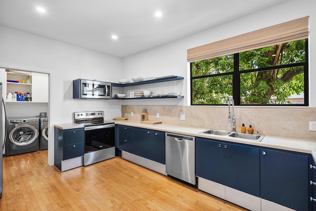 kitchen with separate washer and dryer, appliances with stainless steel finishes, sink, and blue cabinets