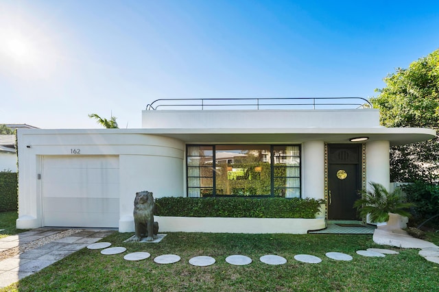 view of front facade featuring a garage, a front yard, and a balcony