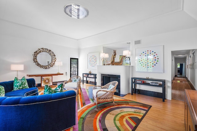 living room featuring hardwood / wood-style flooring and crown molding