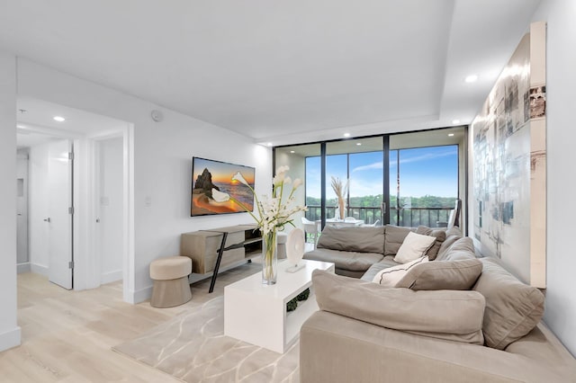 living room featuring floor to ceiling windows and light hardwood / wood-style floors