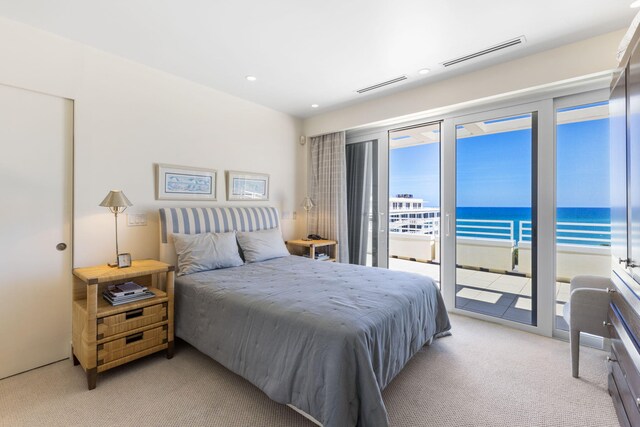 carpeted bedroom with a water view and access to outside