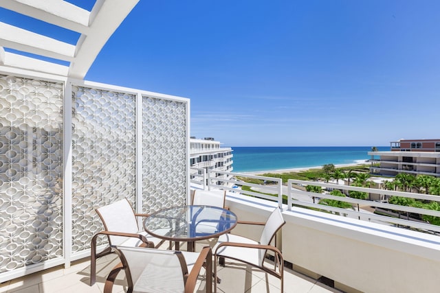 balcony featuring a water view and a view of the beach