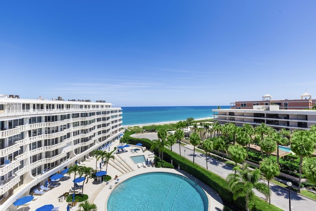 view of swimming pool with a beach view and a water view