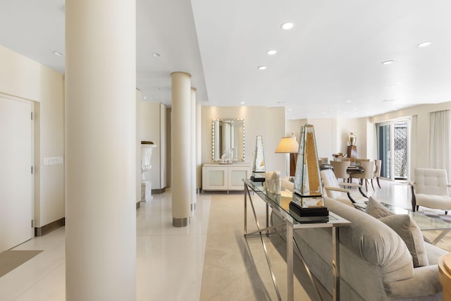 living room featuring decorative columns and light tile patterned floors