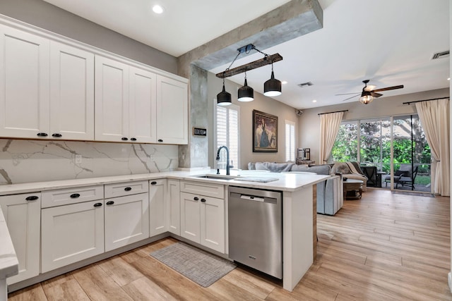 kitchen featuring white cabinetry, sink, stainless steel dishwasher, and decorative light fixtures