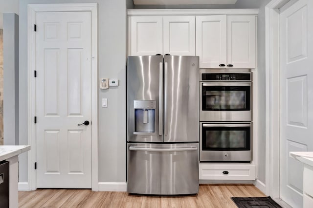 kitchen with white cabinetry, light wood-type flooring, and appliances with stainless steel finishes