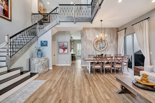 dining room featuring a high ceiling, a notable chandelier, and light hardwood / wood-style floors