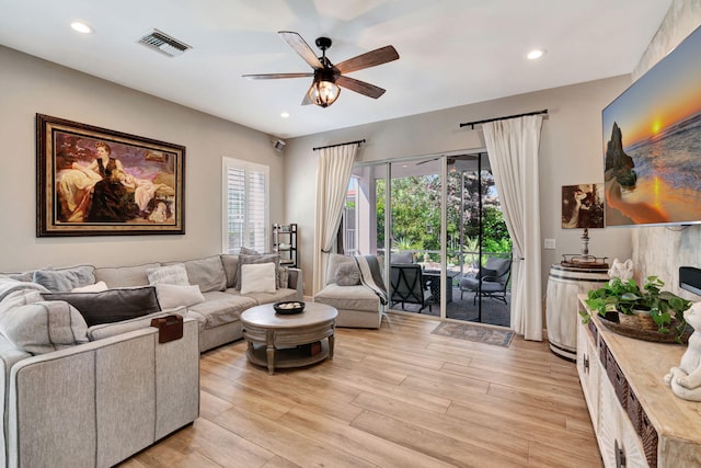 living room with ceiling fan and light hardwood / wood-style floors