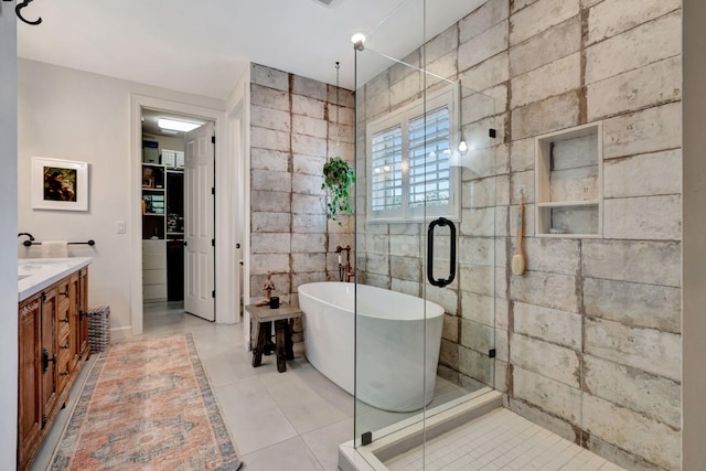 bathroom featuring tile patterned flooring, vanity, separate shower and tub, and tile walls