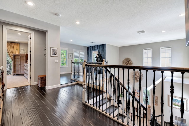 hall featuring dark wood-type flooring and a textured ceiling