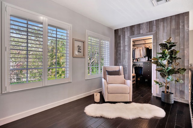 sitting room with dark wood-type flooring and plenty of natural light