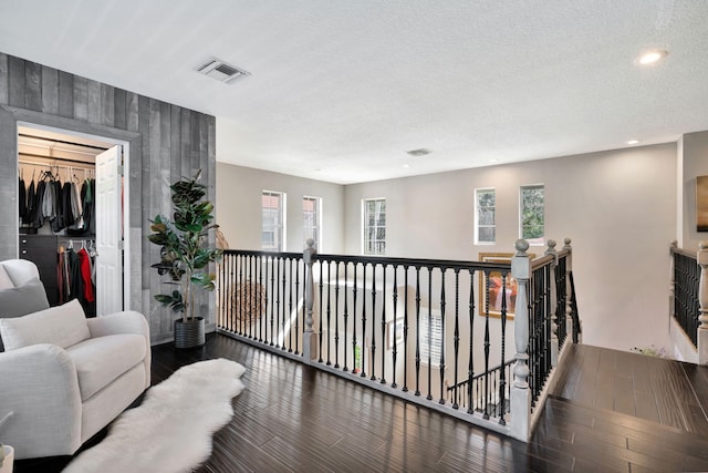 corridor featuring dark hardwood / wood-style flooring and a textured ceiling