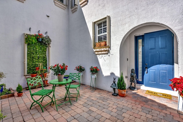 view of exterior entry with a patio area