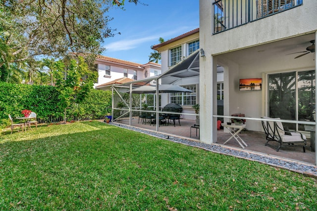 view of yard featuring a patio, a lanai, ceiling fan, and a balcony