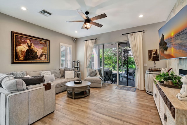 living room featuring ceiling fan and light hardwood / wood-style flooring