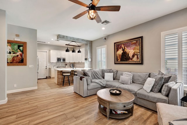 living room featuring ceiling fan and light wood-type flooring