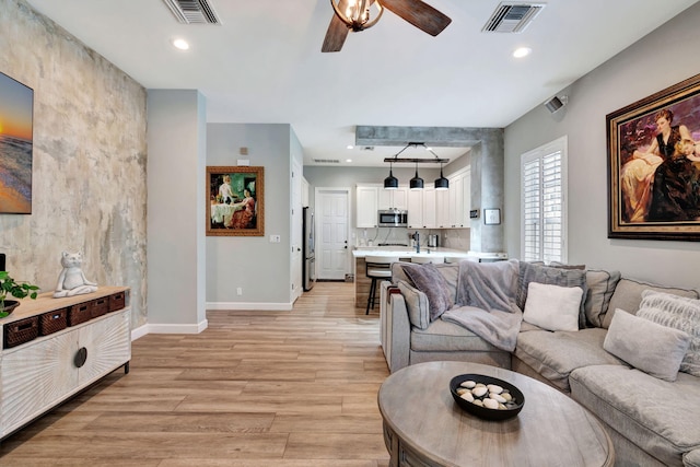 living room featuring ceiling fan and light hardwood / wood-style floors