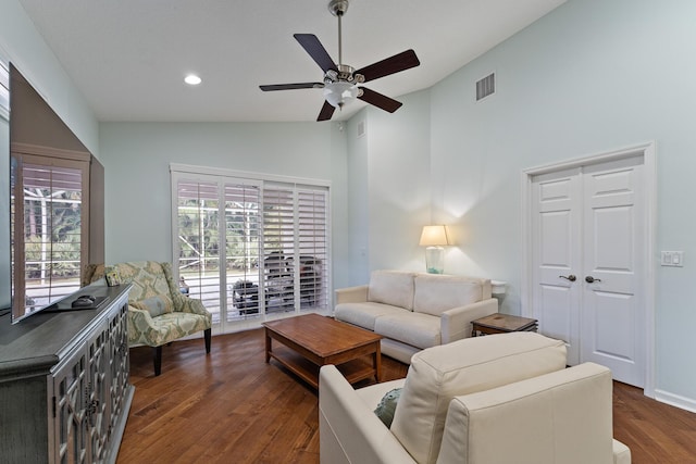 living room with ceiling fan, dark wood-type flooring, and lofted ceiling