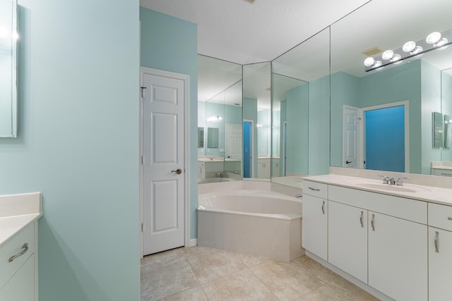 bathroom featuring a bath, vanity, a textured ceiling, and tile patterned flooring
