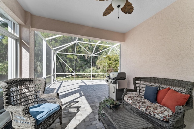 view of patio / terrace featuring glass enclosure, ceiling fan, and a grill