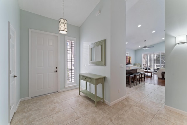 tiled entryway featuring vaulted ceiling and ceiling fan