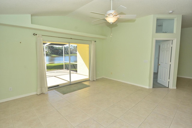 spare room featuring ceiling fan, lofted ceiling, and light tile patterned floors