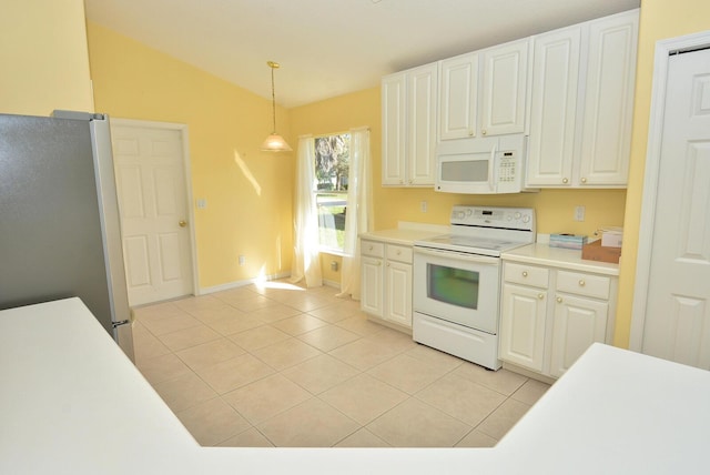 kitchen with light tile patterned flooring, white appliances, hanging light fixtures, and white cabinets