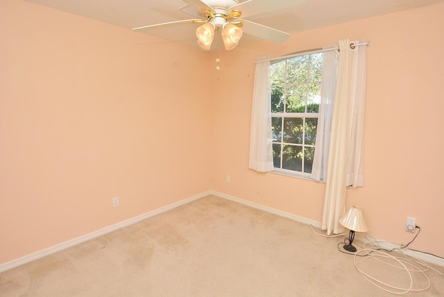 carpeted spare room featuring ceiling fan