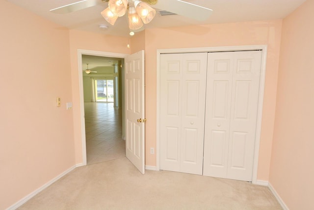 unfurnished bedroom with light carpet, a closet, and ceiling fan