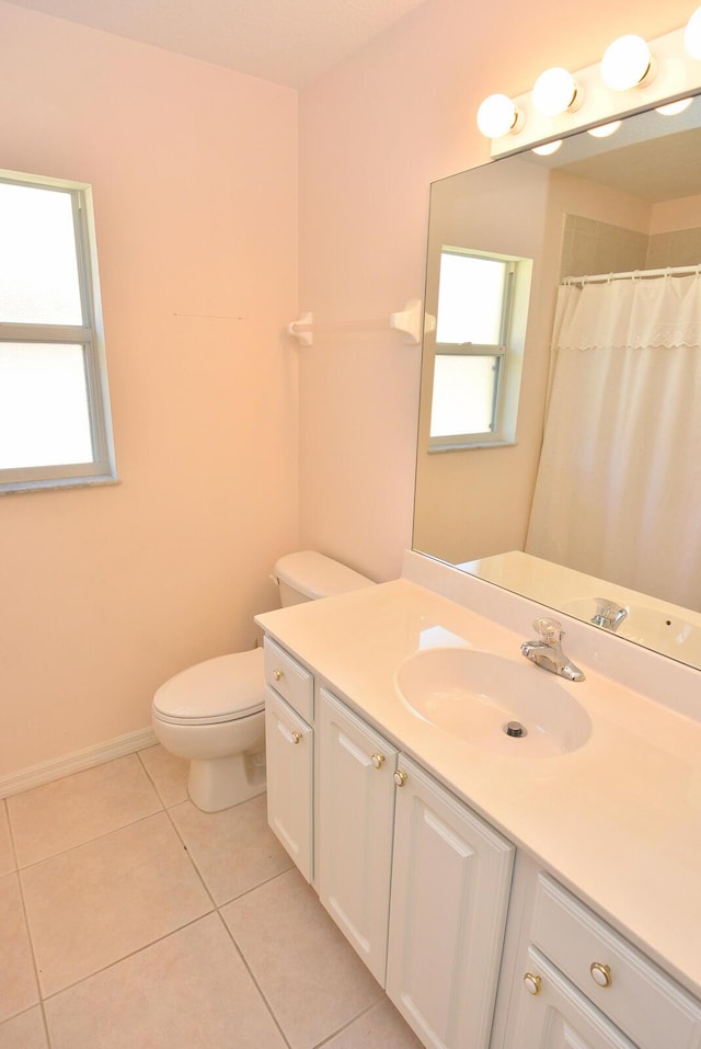 bathroom featuring tile patterned flooring, vanity, a healthy amount of sunlight, and toilet