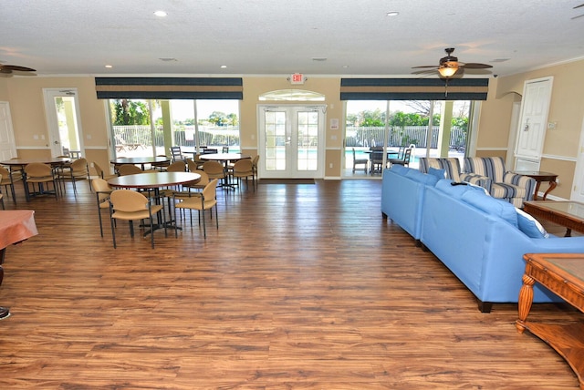 living room with a wealth of natural light, hardwood / wood-style floors, a textured ceiling, and french doors