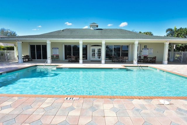 view of pool with french doors, area for grilling, and a patio area