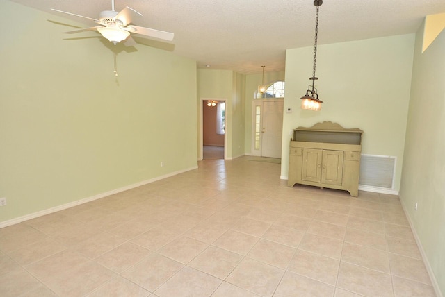 tiled spare room with ceiling fan and a textured ceiling