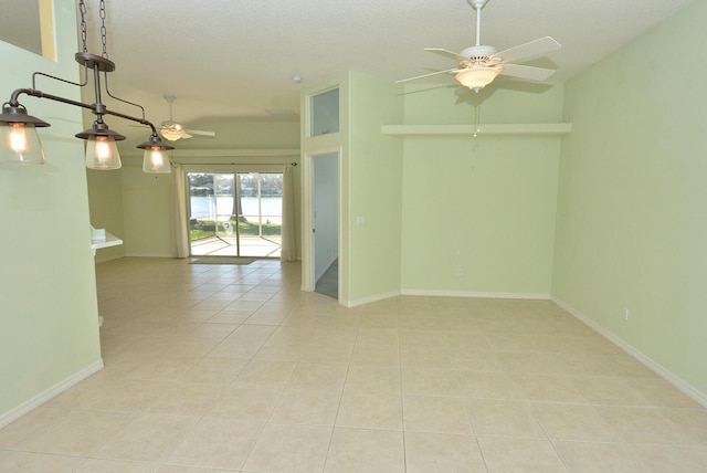 tiled empty room featuring ceiling fan and a textured ceiling