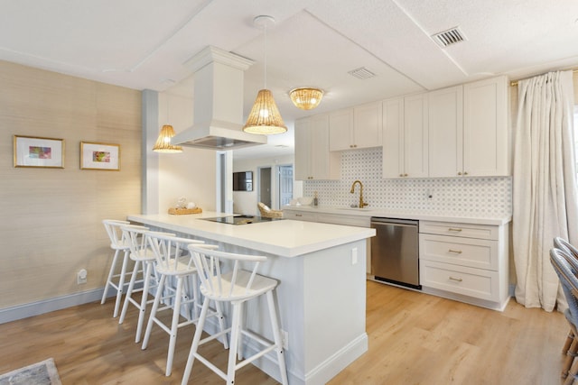 kitchen featuring island exhaust hood, stainless steel dishwasher, black electric cooktop, white cabinets, and decorative light fixtures