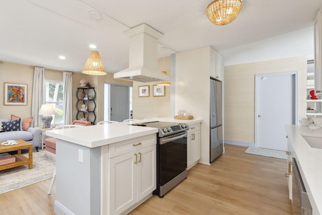 kitchen featuring appliances with stainless steel finishes, decorative light fixtures, white cabinetry, island range hood, and light wood-type flooring