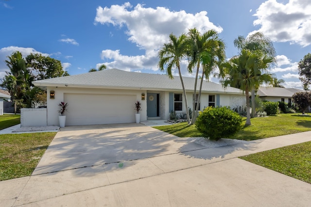 single story home featuring a garage and a front lawn