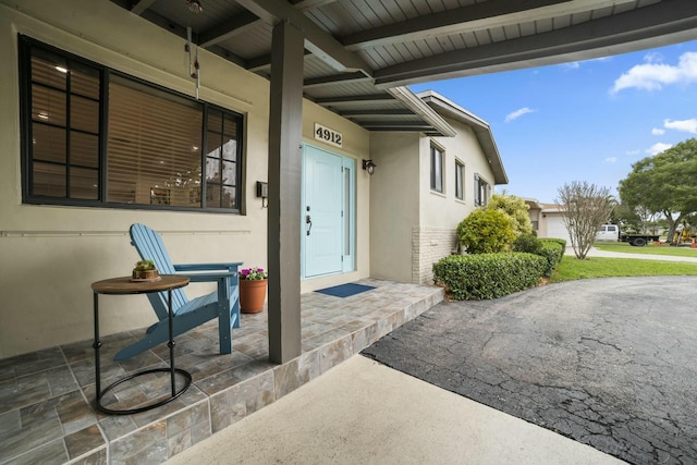 view of exterior entry with a patio