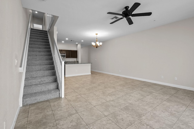 stairway with tile patterned flooring and ceiling fan with notable chandelier