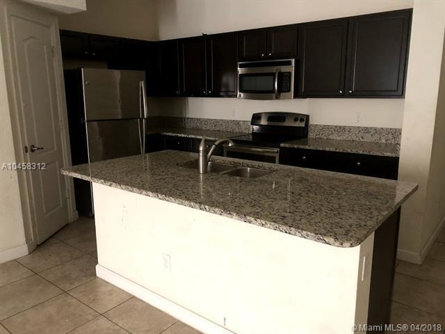 kitchen with appliances with stainless steel finishes, a kitchen island with sink, light tile patterned floors, and sink