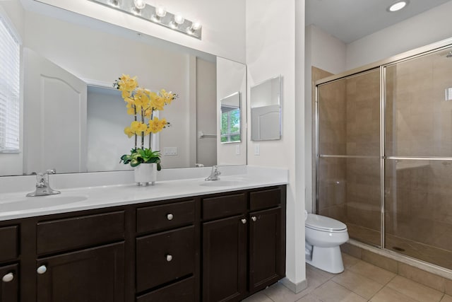 bathroom with vanity, tile patterned floors, a shower with door, and toilet