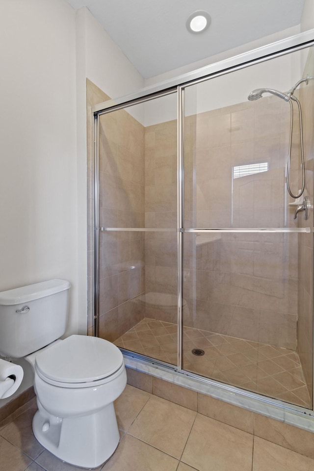 bathroom featuring toilet, tile patterned floors, and walk in shower