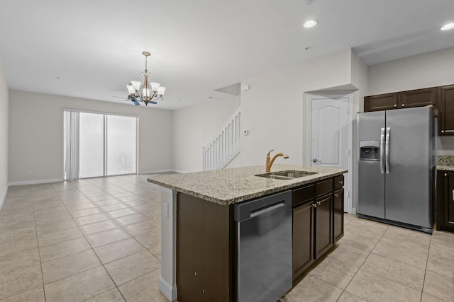 kitchen featuring appliances with stainless steel finishes, sink, hanging light fixtures, a notable chandelier, and a center island with sink