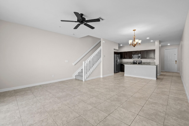 unfurnished living room featuring ceiling fan with notable chandelier and light tile patterned floors